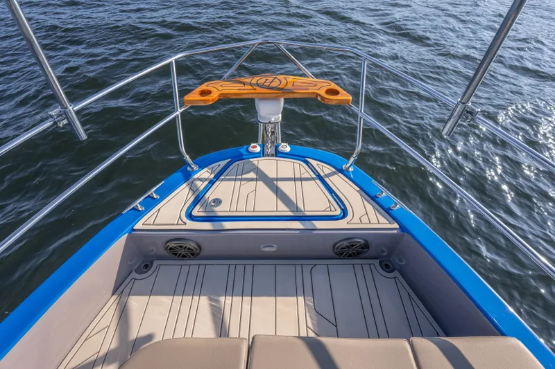 Slide: The Image of Bow view of 2026 Hanover 347 boat with sleek design and blue accents on water. - 29