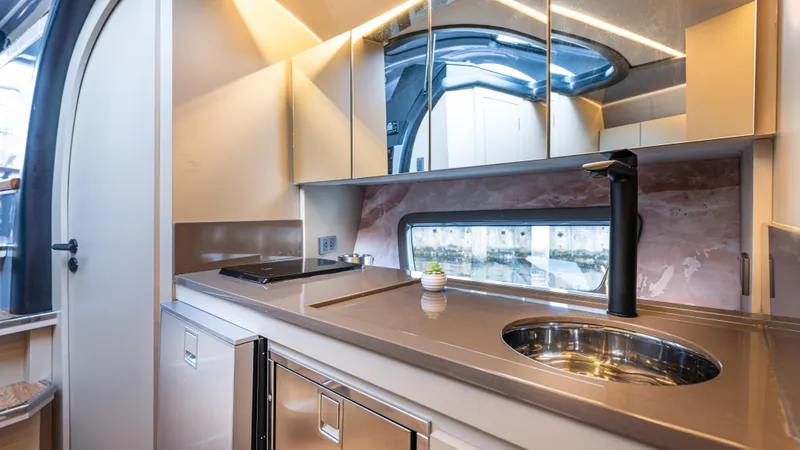 Slide: The Image of Modern kitchen interior in 2025 Hanover 415 RV, featuring sleek design and compact appliances. - 17