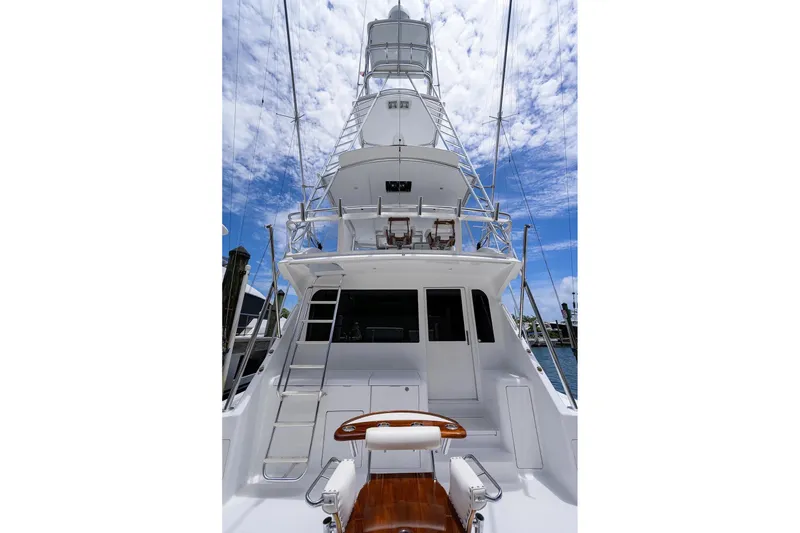Slide: The Image of 2001 Viking 55 Convertible yacht with tower, docked under a blue sky. - 22
