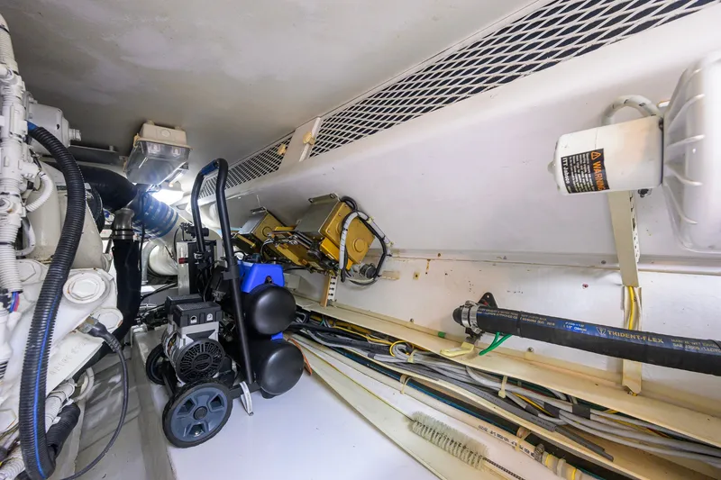 Slide: The Image of Engine room of a 2001 Viking 55 Convertible yacht, showcasing mechanical components and wiring. - 88