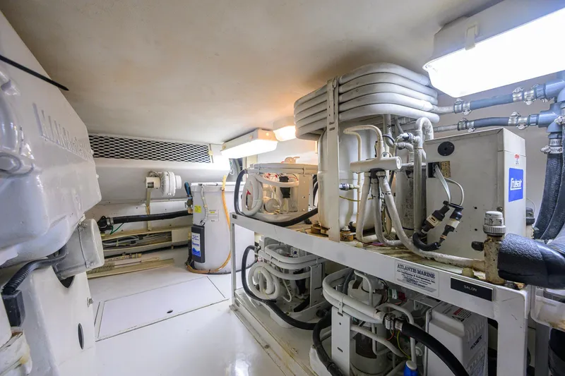 Slide: The Image of Engine room of a 2001 Viking 55 Convertible yacht, showcasing mechanical equipment and piping. - 87