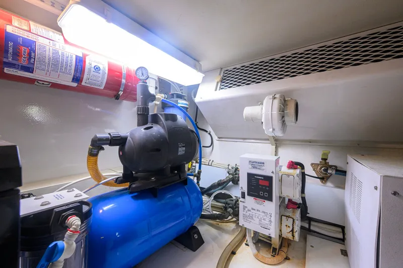 Slide: The Image of Engine room of 2001 Viking 55 Convertible yacht with equipment and fire extinguisher. - 84