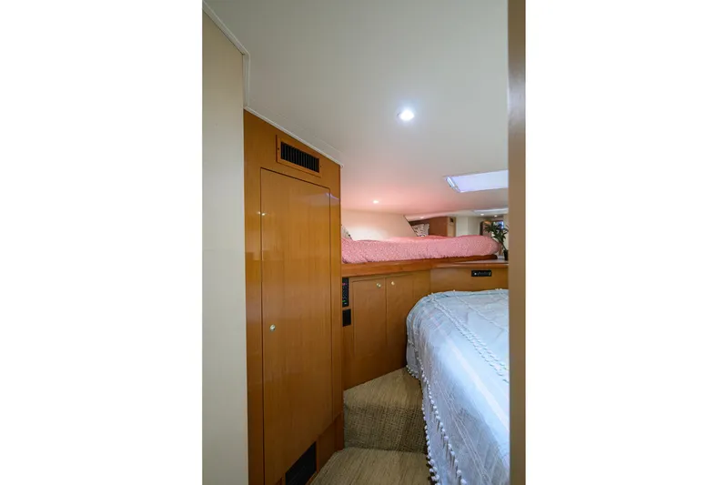 Slide: The Image of Interior cabin of 2001 Viking 55 Convertible yacht with cozy bedding and wooden cabinetry. - 66