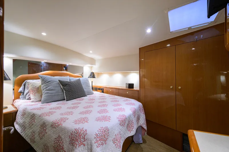 Slide: The Image of Luxurious bedroom interior of 2001 Viking 55 Convertible yacht with elegant bedding and wood cabinetry. - 56