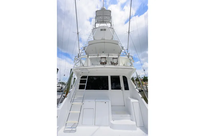 Slide: The Image of 2001 Viking 55 Convertible yacht, rear view with tower and ladder, docked under cloudy sky. - 21