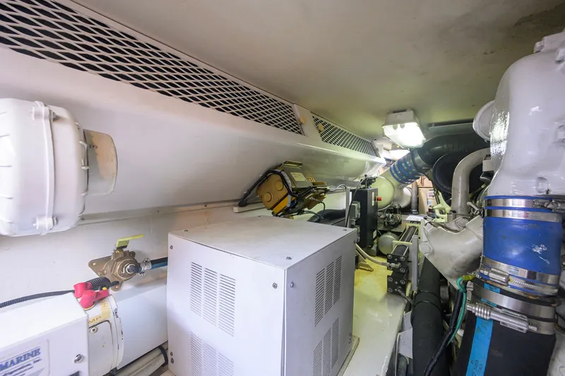 Slide: The Image of Engine room of a 2001 Viking 55 Convertible yacht, showcasing mechanical components and piping. - 85