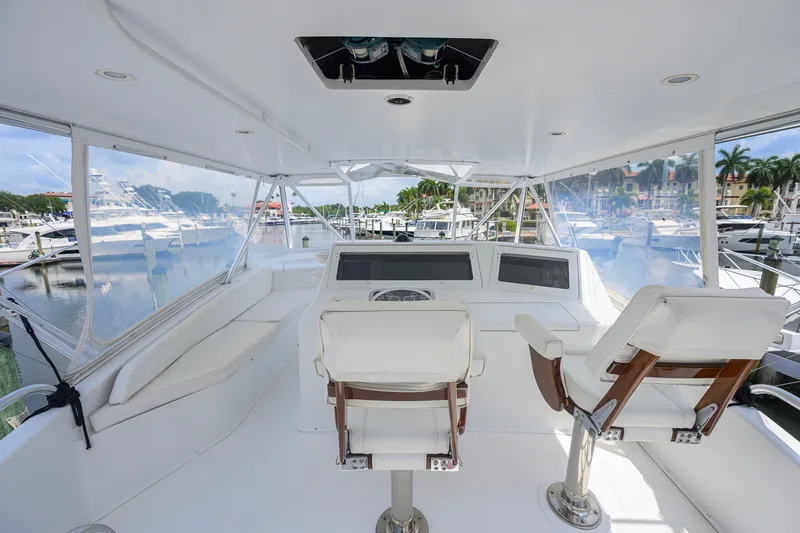 Slide: The Image of 2001 Viking 55 Convertible yacht helm with white seating, marina view. - 26