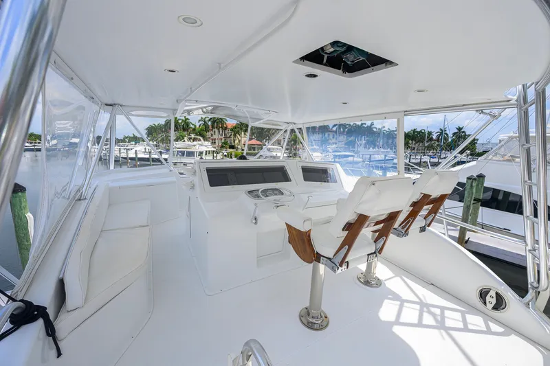 Slide: The Image of 2001 Viking 55 Convertible yacht helm with white seating and marina view. - 25