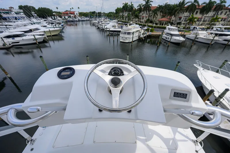 Slide: The Image of Steering wheel of a 2001 Viking 55 Convertible yacht in a marina setting. - 39