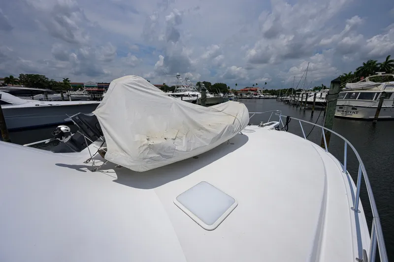 Slide: The Image of 2001 Viking 55 Convertible yacht docked, covered equipment on deck, cloudy sky background. - 15