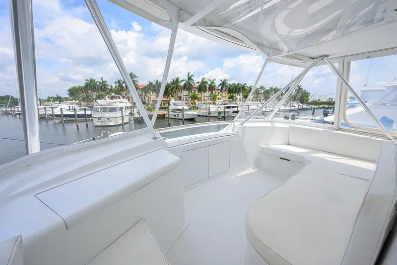 Slide: The Image of 2001 Viking 55 Convertible yacht interior with marina view, featuring sleek white seating and modern design. - 33
