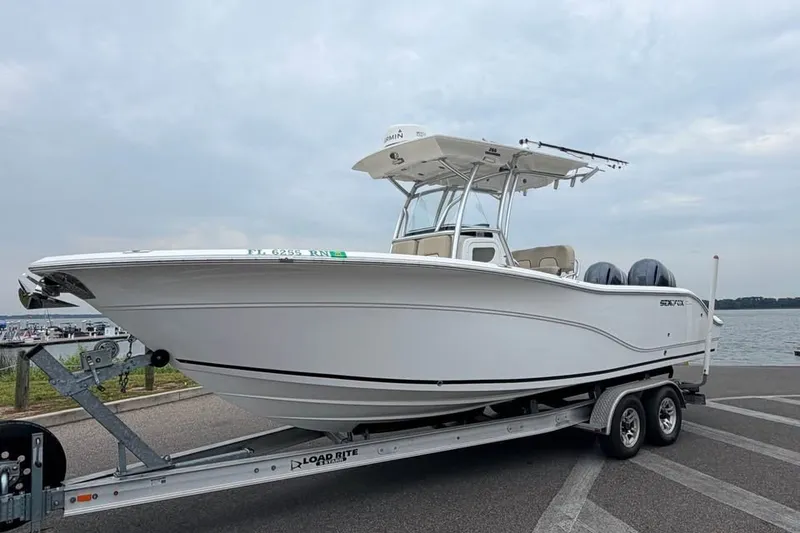 Slide: The Image of 2018 Sea Fox 266 Commander boat on trailer by waterfront, overcast sky. - 0