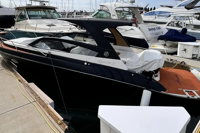 Slide: The Image of Luxury Hanover 305 yacht docked at marina, 2026 model, sleek black design. - 1