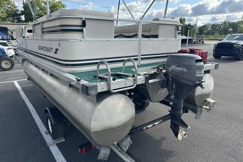 Slide: The Image of 1999 Starcraft Starfish 180 pontoon boat with outboard motor in parking lot. - 6