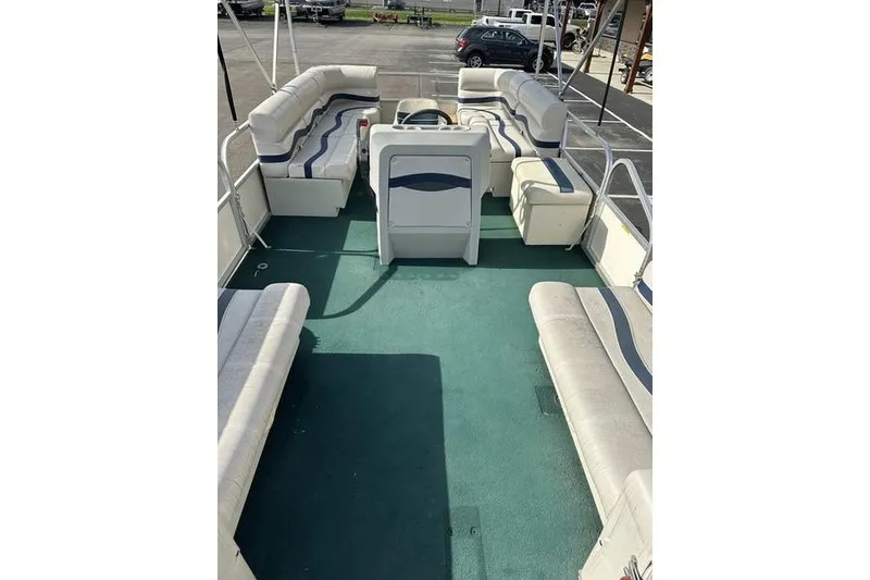 Slide: The Image of 1999 Starcraft Starfish 180 pontoon boat interior with spacious seating and green carpet. - 7