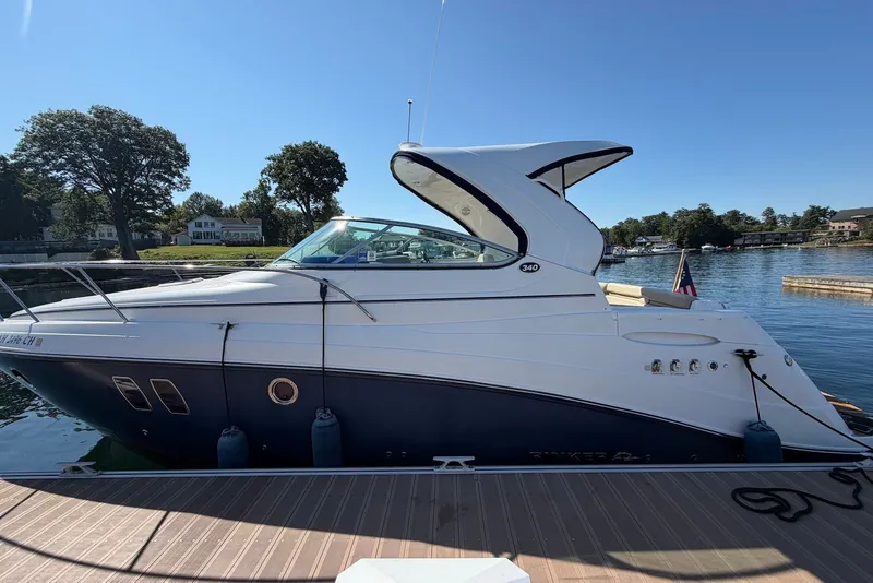 The Image of 2015 Rinker 340 Express Cruiser docked by a scenic lakeside. - 0