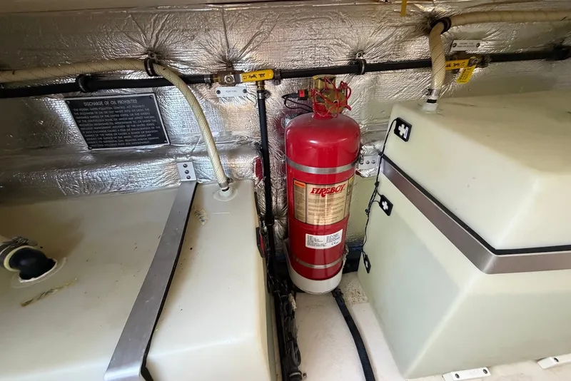 Slide: The Image of Engine compartment of 2015 Rinker 340 Express Cruiser with fire extinguisher and storage tanks. - 39