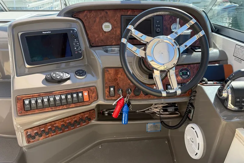 Slide: The Image of 2015 Rinker 340 Express Cruiser helm with steering wheel and control panel. - 19