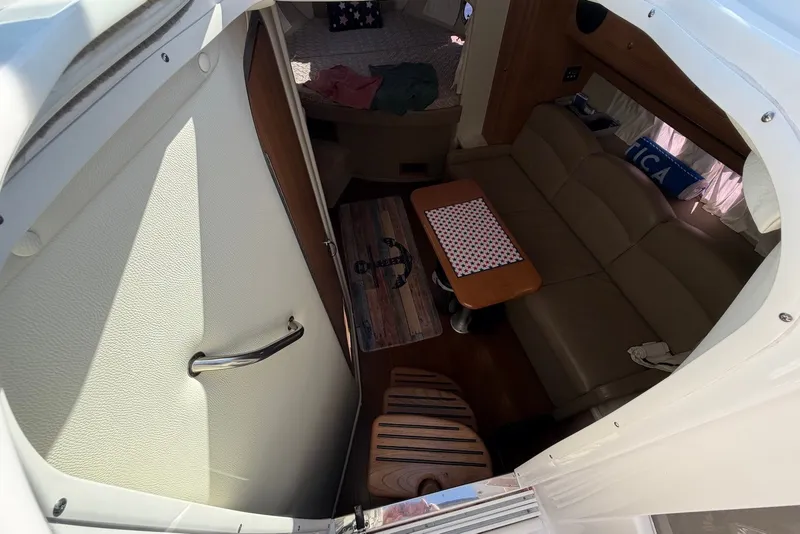 Slide: The Image of Interior view of 2015 Rinker 340 Express Cruiser, featuring a cozy seating area and table. - 26