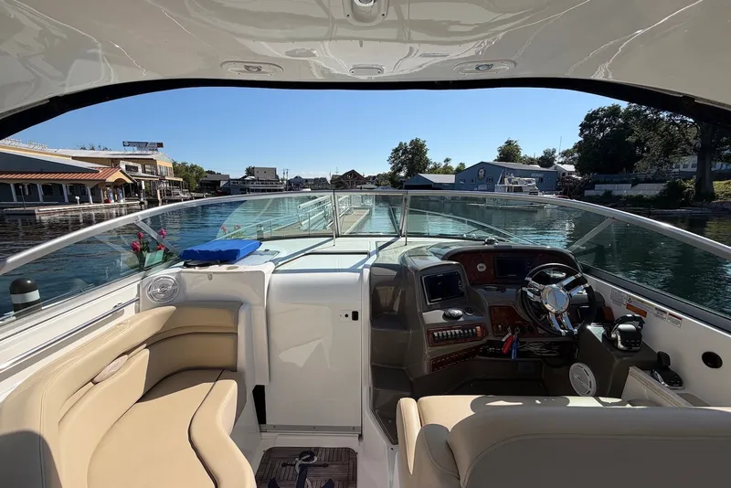 Slide: The Image of 2015 Rinker 340 Express Cruiser cockpit with modern controls, docked near waterfront buildings. - 25