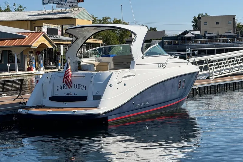Slide: The Image of 2015 Rinker 340 Express Cruiser docked at marina, displaying American flag. - 13