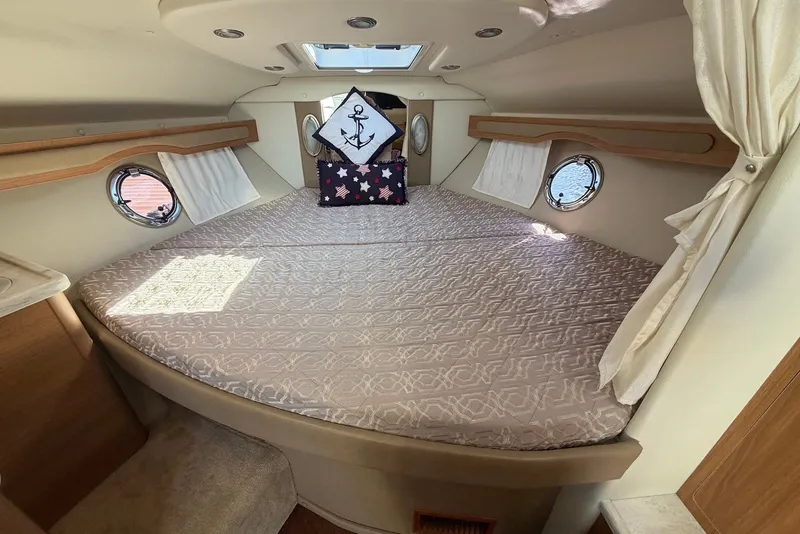 Slide: The Image of Cozy cabin interior of 2015 Rinker 340 Express Cruiser with nautical-themed decor. - 32