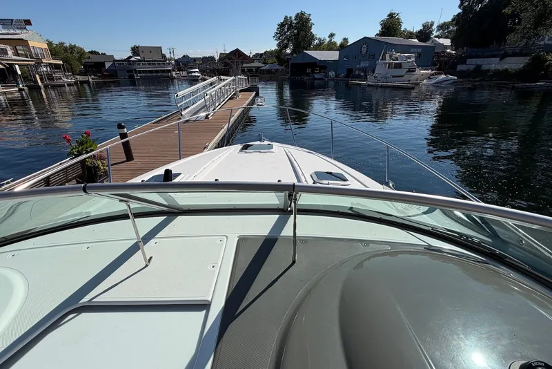 Slide: The Image of 2015 Rinker 340 Express Cruiser docked at a scenic marina. - 14
