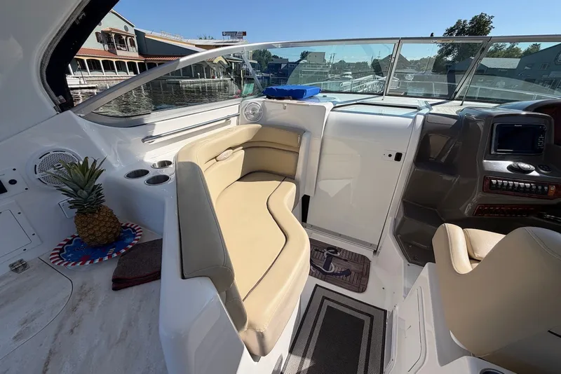 Slide: The Image of Interior of a 2015 Rinker 340 Express Cruiser with beige seating and a pineapple decoration. - 24