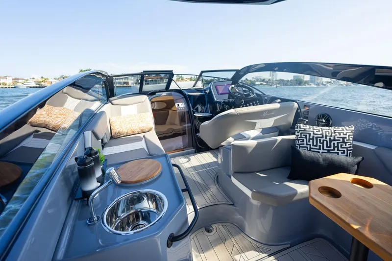 Slide: The Image of Luxurious 2026 Hanover 305 boat interior with modern seating, sink, and scenic water view. - 19
