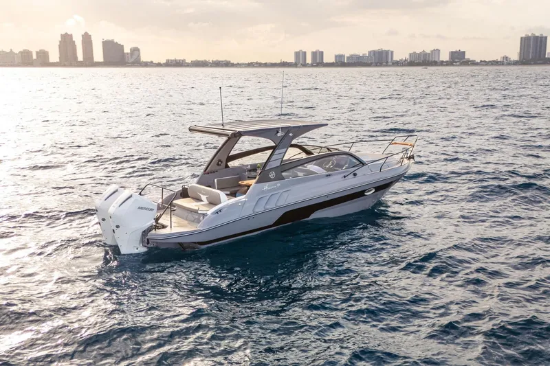 Slide: The Image of 2026 Hanover 305 boat cruising on open water near city skyline. - 4