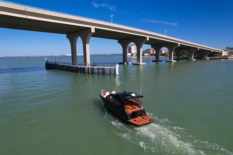 Slide: The Image of Boat cruising under bridge on sunny day, featuring Hanover 355 model, 2026. - 3