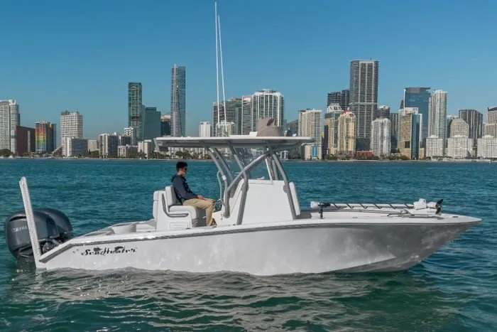 The Image of A modern, white SeaHunter 25 Floridian on the water with a city skyline and skyscrapers in the background. - 1