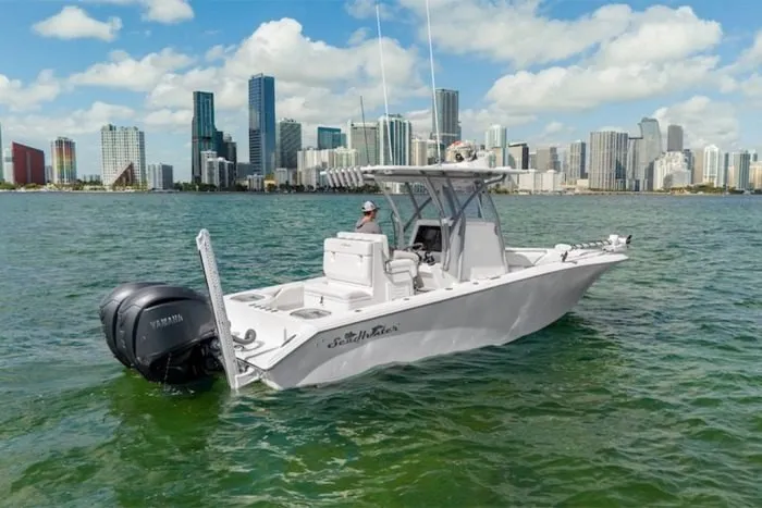 Slide: The Image of A 2027 SeaHunter 25 Floridian on calm waters with a city skyline in the background. - 3