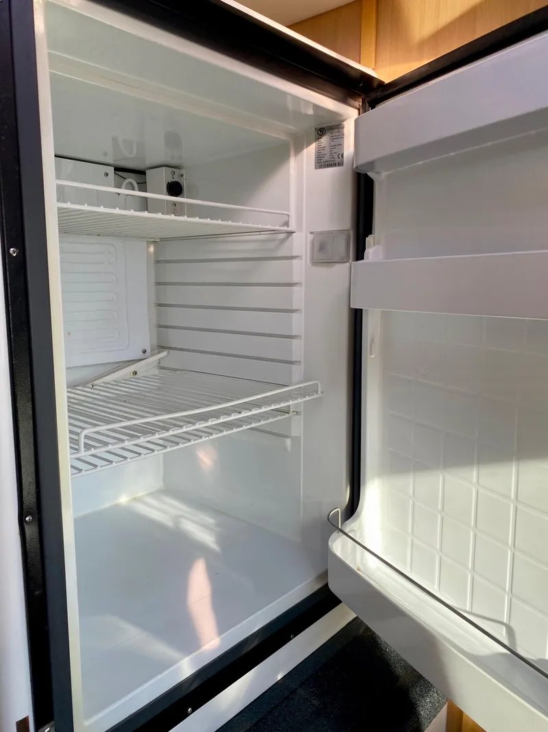 Slide: The Image of Open refrigerator with two wire shelves and a door shelf. - 35