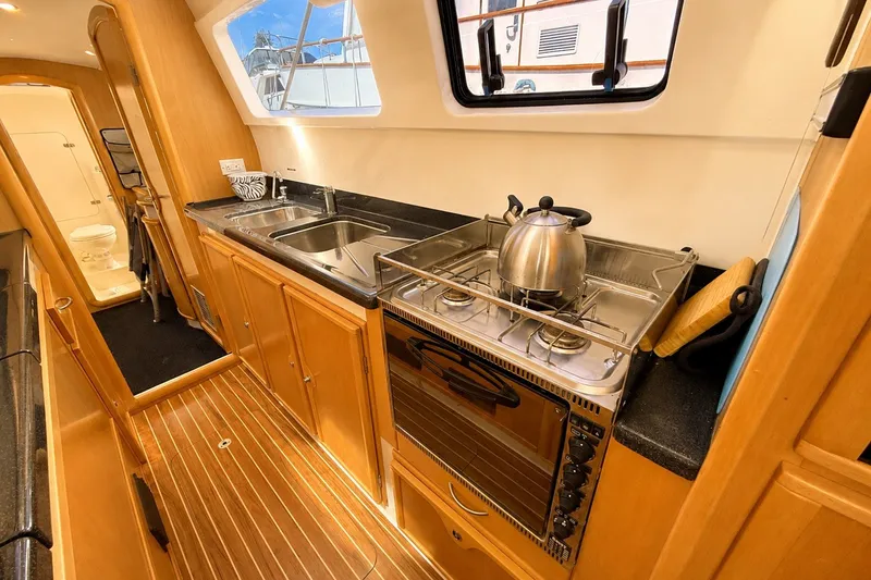 Slide: The Image of Galley counters w/ stove, oven & broiler, double stainless steel sinks and ample storage outboard on starboard side hull - 32
