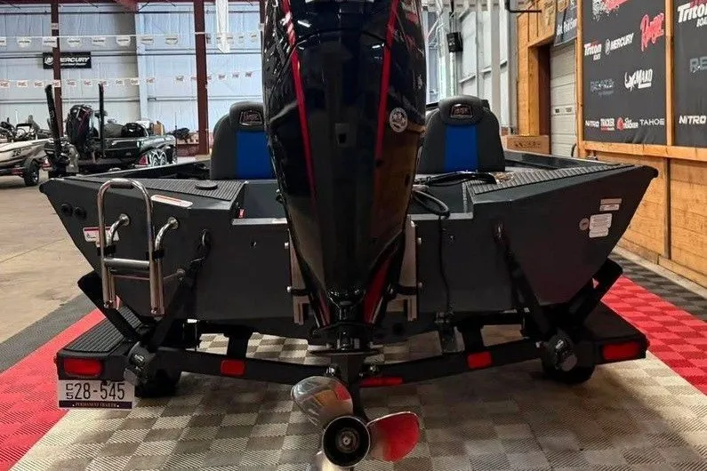 Slide: The Image of 2024 Ranger RT188P boat in showroom, rear view with motor and trailer. - 8