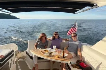 Slide: The Image of Three people relaxing on a 2020 Sea Ray Sundancer 320 yacht with ocean view. - 6