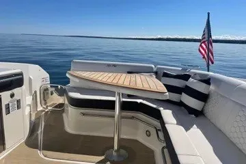 Slide: The Image of 2020 Sea Ray Sundancer 320 yacht with elegant seating and table, cruising on calm waters. - 17