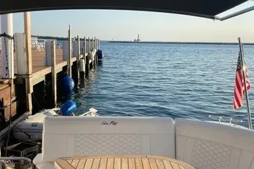 Slide: The Image of 2020 Sea Ray Sundancer 320 docked by a serene waterfront with American flag. - 21