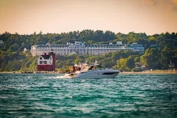 Slide: The Image of 2020 Sea Ray Sundancer 320 cruising near a scenic shoreline with historic architecture. - 4