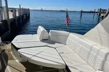 Slide: The Image of 2020 Sea Ray Sundancer 320 with spacious seating, docked by a serene waterfront. - 14