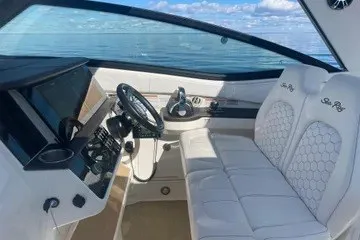 Slide: The Image of 2020 Sea Ray Sundancer 320 cockpit with luxurious seating and modern controls, overlooking the ocean. - 18
