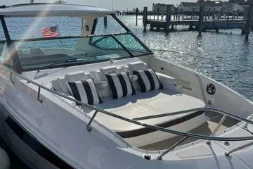 Slide: The Image of 2020 Sea Ray Sundancer 320 yacht with striped cushions, docked by a sunny waterfront. - 20