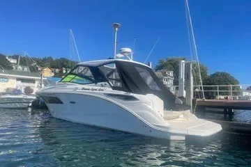 Slide: The Image of 2020 Sea Ray Sundancer 320 yacht docked in a marina under clear blue skies. - 2