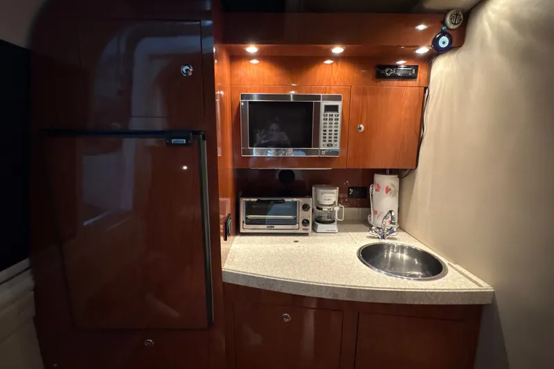 Slide: The Image of Compact kitchen area in a 2007 Regal Commodore 3760 IO yacht with appliances and sink. - 27