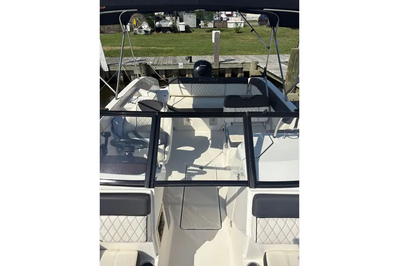 Slide: The Image of 2023 Bayliner DX 2200 boat interior with seating and steering wheel. - 4