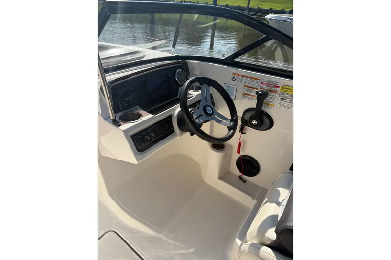 Slide: The Image of 2023 Bayliner DX 2200 boat cockpit with steering wheel and control panel. - 5