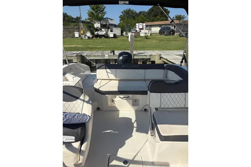 Slide: The Image of 2023 Bayliner DX 2200 boat interior with seating and outdoor view. - 6