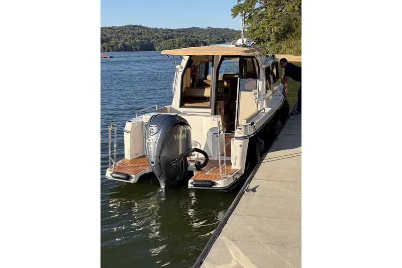 Slide: The Image of 2022 Ranger Tugs R-25 docked by a scenic lakeside with Yamaha outboard motor. - 4