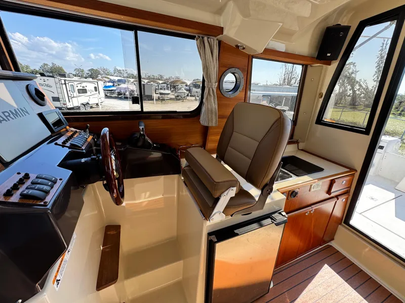 Slide: The Image of Interior of 2022 Ranger Tugs R-25 boat with helm, seating, and kitchenette. - 9